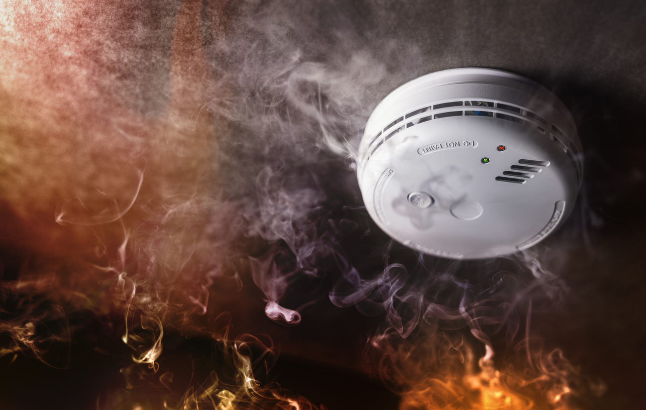 Smoke detector and fire alarm in action background
